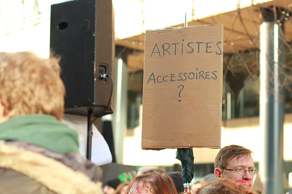 Protest sign reading “Artistes accessoires ?”, photographed in Bruxelles, Belgium.