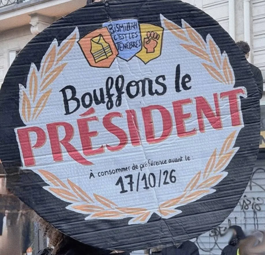 Protest sign reading “Bouffons le président (à consommer de préférence avant le 17/10/26)” at “Manifestation du 17 octobre 2026 en France” in France.
