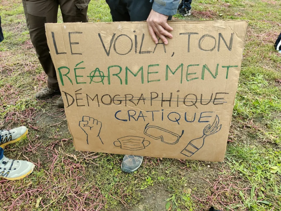 Protestbord met de tekst ‘Le voilà, ton réarmement démocratique’ tijdens ‘Manifestation du 24 octobre 2026 en France’ in Poitiers, Frankrijk.