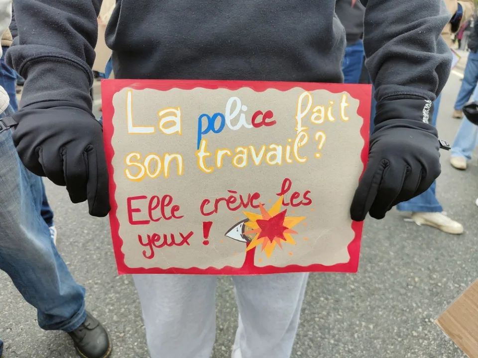 Protestbord met de tekst ‘La police fait son travail ? Elle crève les yeux !’ tijdens ‘Manifestation du 24 octobre 2026 en France’ in Poitiers, Frankrijk.