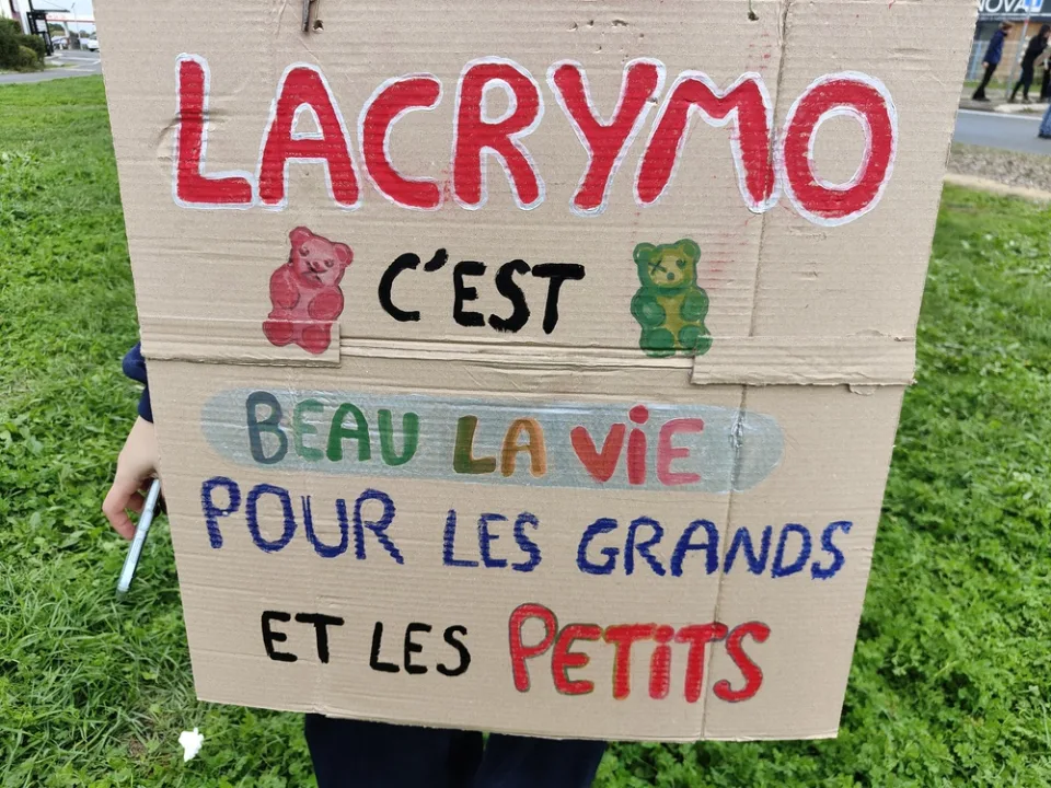 لافتة كُتب عليها «Lacrymo c’est beau la vie pour les grands et les petits» خلال «Manifestation du 24 octobre 2026 en France» في Poitiers, فرنسا.