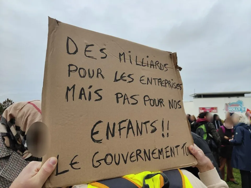 لافتة كُتب عليها «Des milliards pour les entreprises mais pas pour nos enfants !! Le gouvernement tue» خلال «Manifestation du 24 octobre 2026 en France» في Poitiers, فرنسا.
