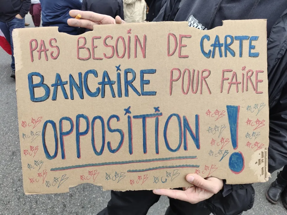 لافتة كُتب عليها «Pas besoin de carte bancaire pour faire opposition !» خلال «Manifestation du 24 octobre 2026 en France» في Poitiers, فرنسا.