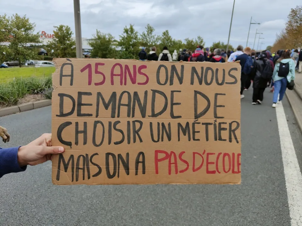 لافتة كُتب عليها «À 15 ans on nous demande de choisir un métier mais on a pas d’école» خلال «Manifestation du 24 octobre 2026 en France» في Poitiers, فرنسا.