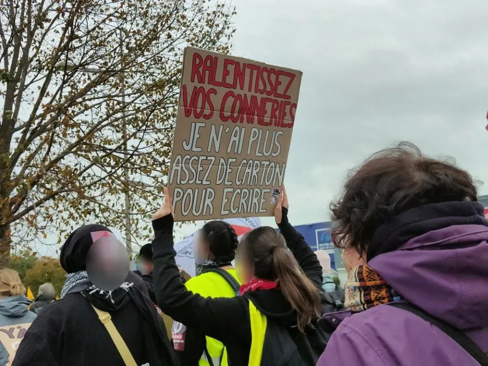 لافتة كُتب عليها «Ralentissez vos conneries, je n’ai plus assez de carton pour écrire» خلال «Manifestation du 24 octobre 2026 en France» في Poitiers, فرنسا.
