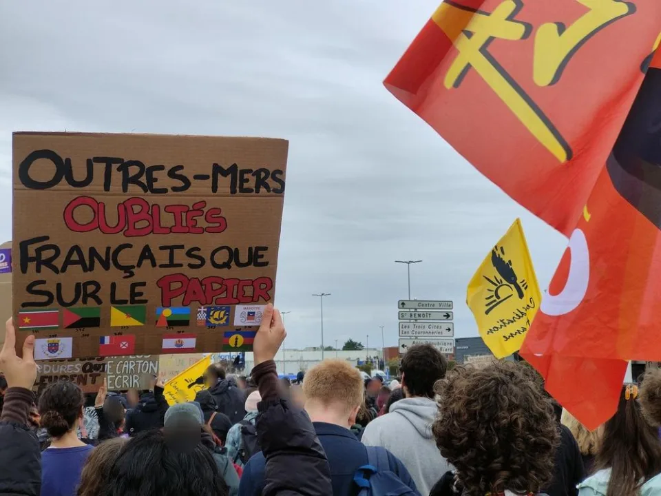 لافتة كُتب عليها «Outres-mers oubliés, français que sur le papier» خلال «Manifestation du 24 octobre 2026 en France» في Poitiers, فرنسا.