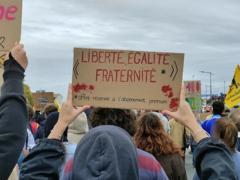 لافتة كُتب عليها «Liberté, égalité, fraternité* — *Offre réservée à l’abonnement premium» خلال «Manifestation du 24 octobre 2026 en France» في Poitiers, فرنسا.